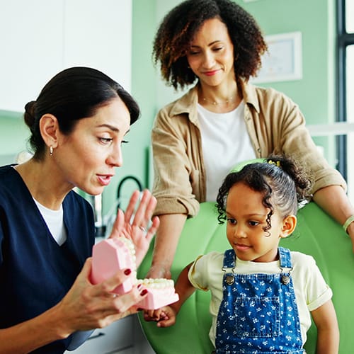 : Social work degree in UK – female social worker guiding child and mother in a healthcare