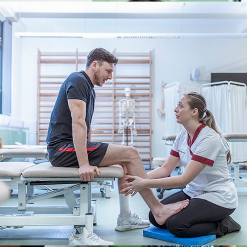 Physiotherapy student supporting patient in clinic session, representing career in rehabilitation and practical training in healthcare.