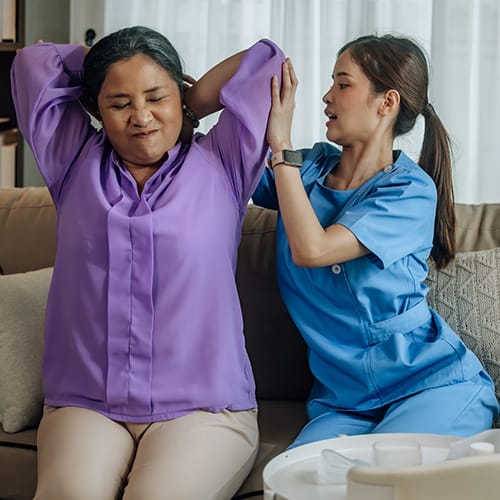 Student assisting patient with therapy exercises - study occupational therapy abroad