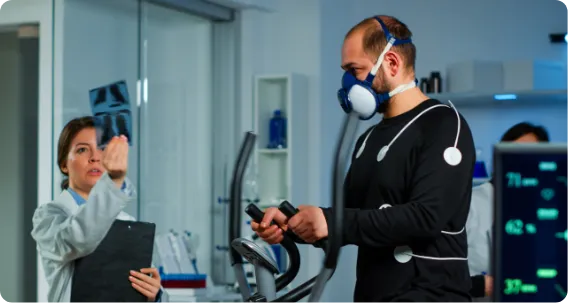 Bachelor of Exercise and Sports Science graduate monitoring athlete during fitness testing with specialized equipment