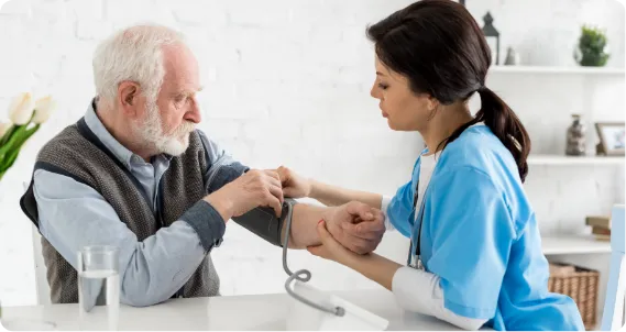BSc Adult Nursing student in UK checking blood pressure of elderly patient during practical training