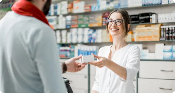 pharmacy professional assisting a customer at the counter during a Pharmacy Technician course training session