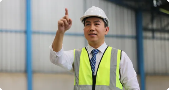 An engineer in a safety vest and helmet points upward, representing MSc Transport Engineering and Planning abroad.